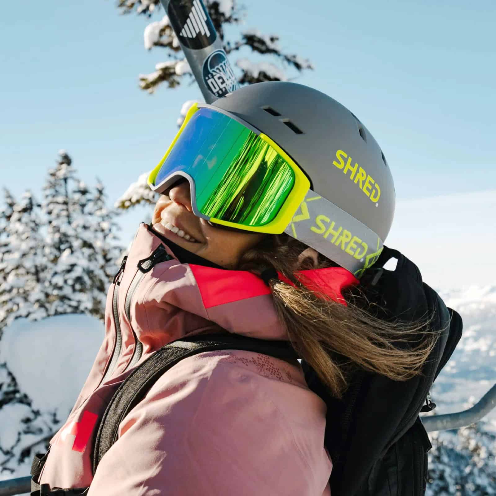 Casco da sci con visiera colorata, donna che si gode la neve in montagna in inverno.