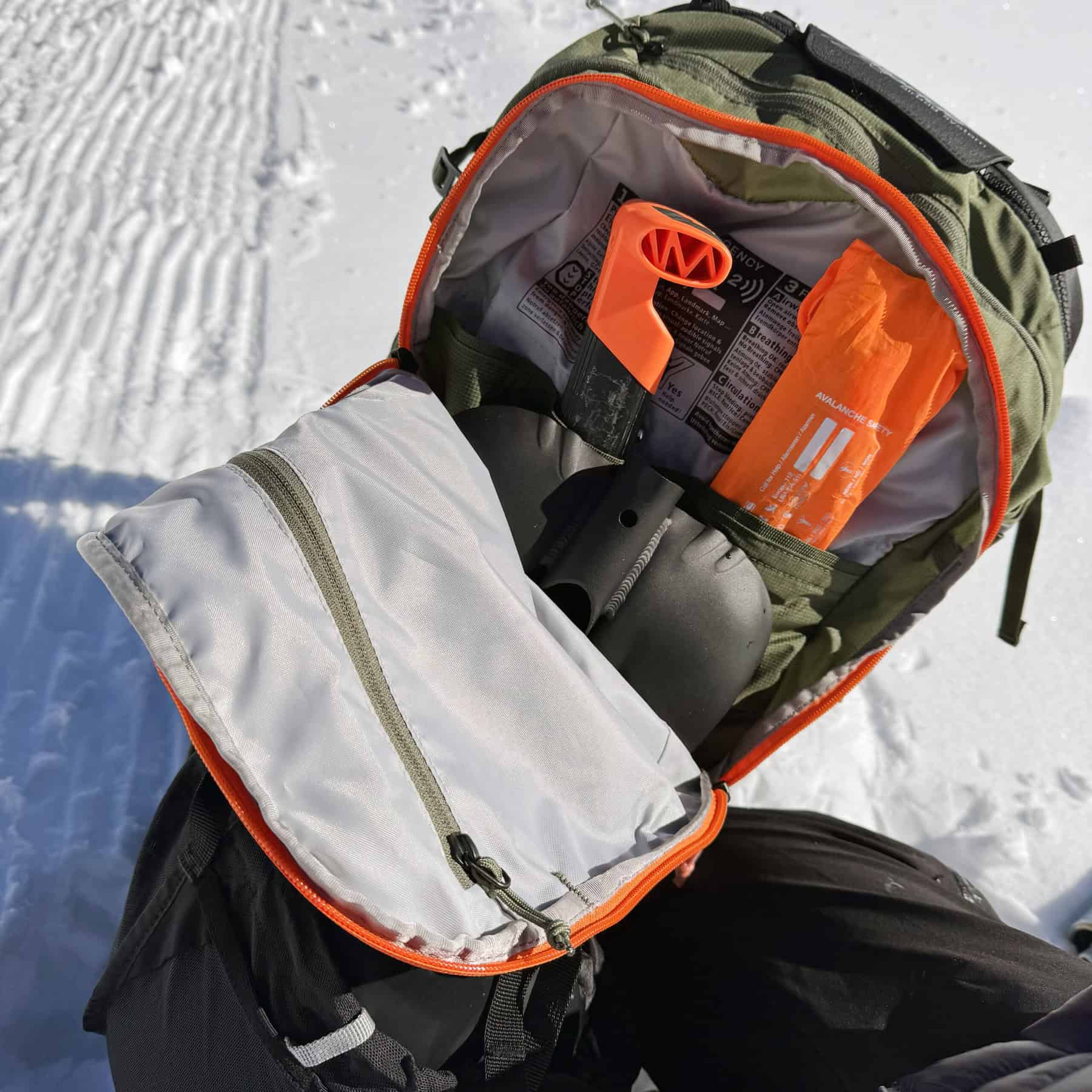 Il vano esterno per riporre il kit sicurezza, artva, pala, sonda, con la zip arancione.