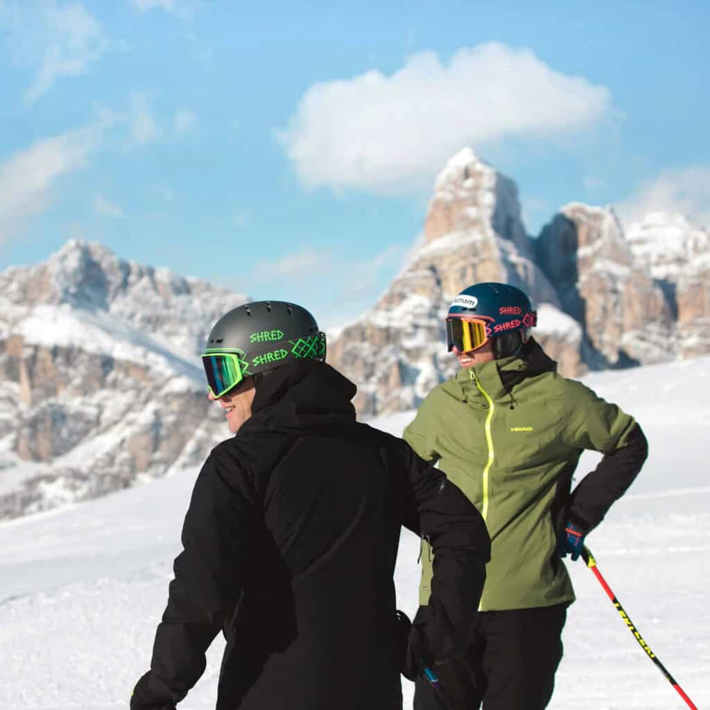 Casco da sci con maschera, abbigliamento tecnico in montagna, attività outdoor invernali, sicurezza sci neve, attrezzatura sport invernali.