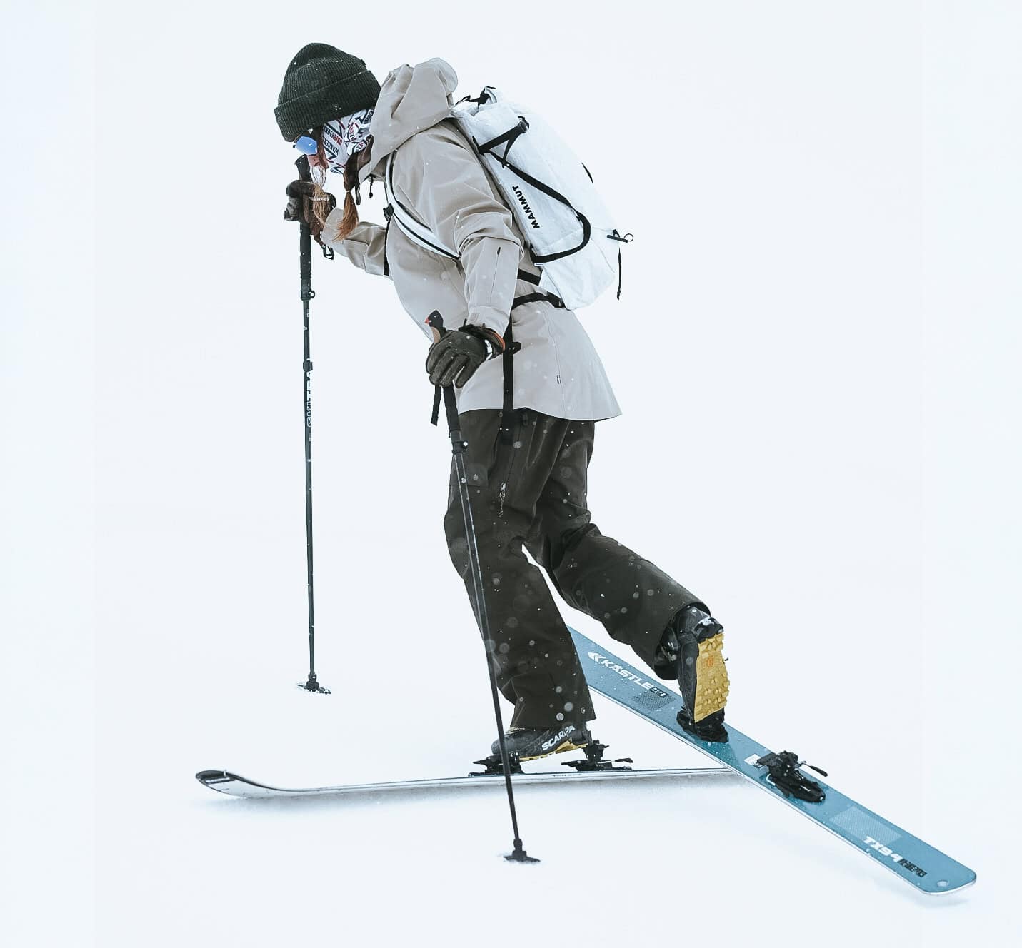 Scialpinista in salita con pelli di foca su pendio innevato, durante un’uscita di sci alpinismo in ambiente alpino