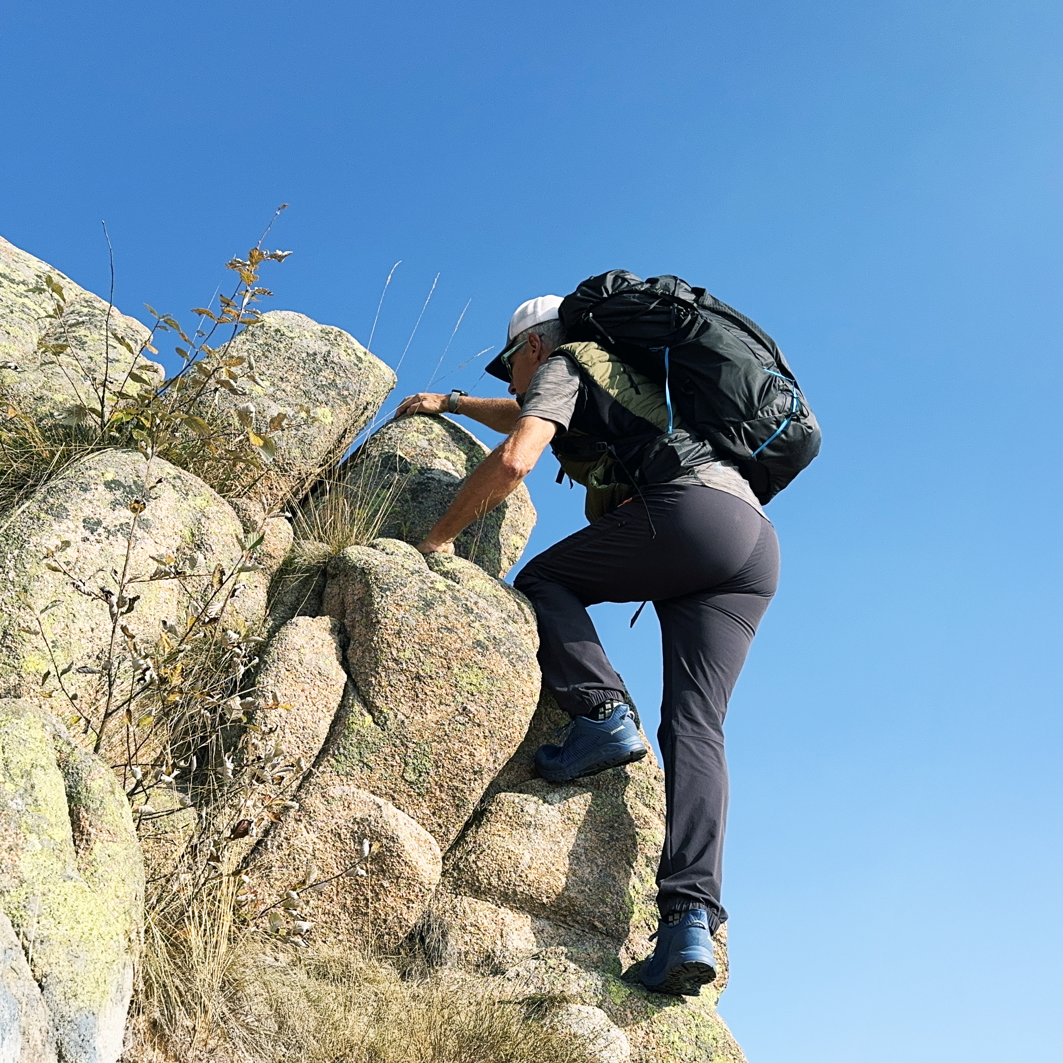 Escursionista con zaino in salita su parete rocciosa al Mottarone con Meindl Power Walker 4.2 Clima