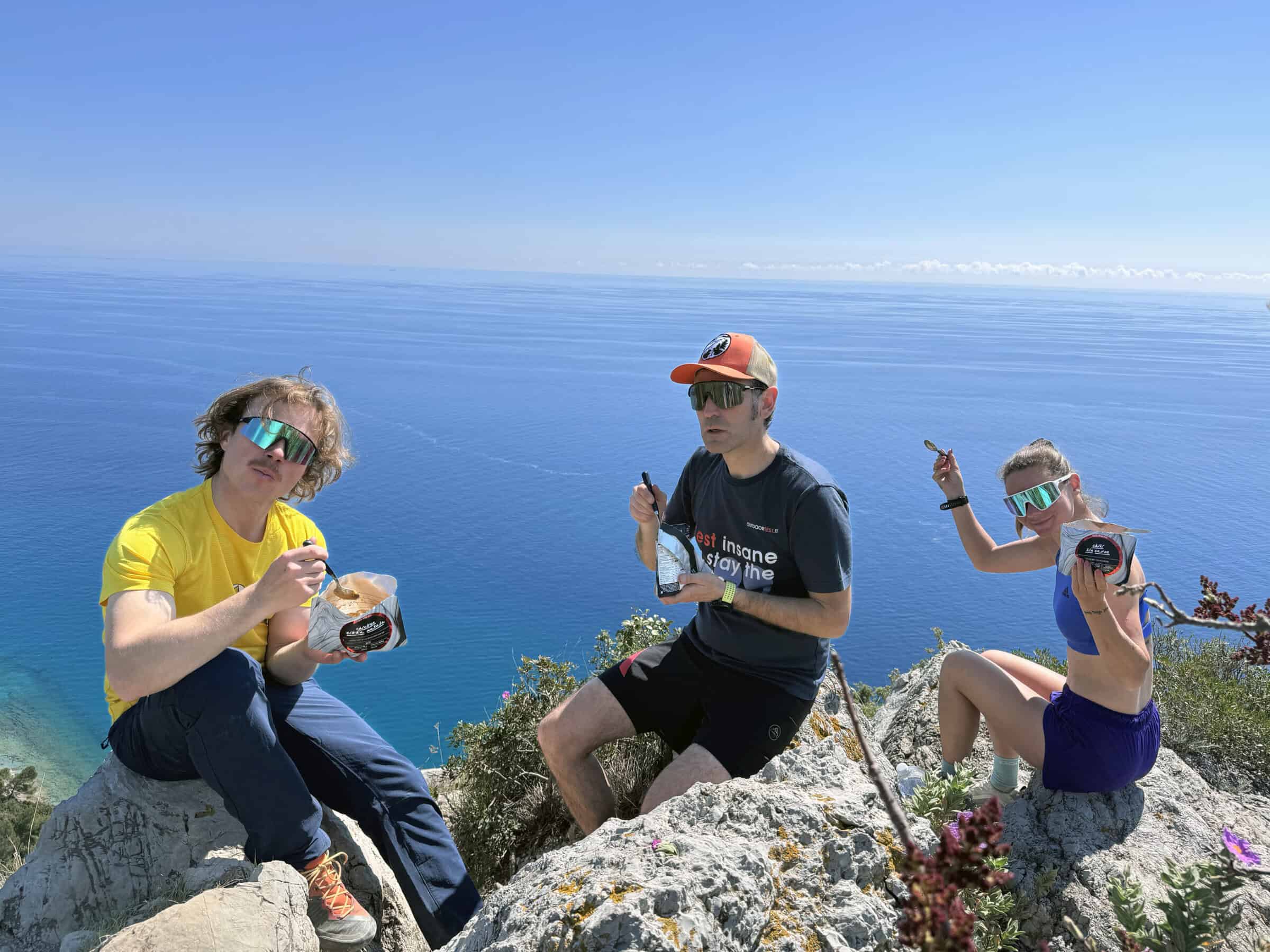 Team tester Outdoortest pranza con pasti liofilizzati Lyofood sulla scogliera sopra il mare a Finale Ligure
