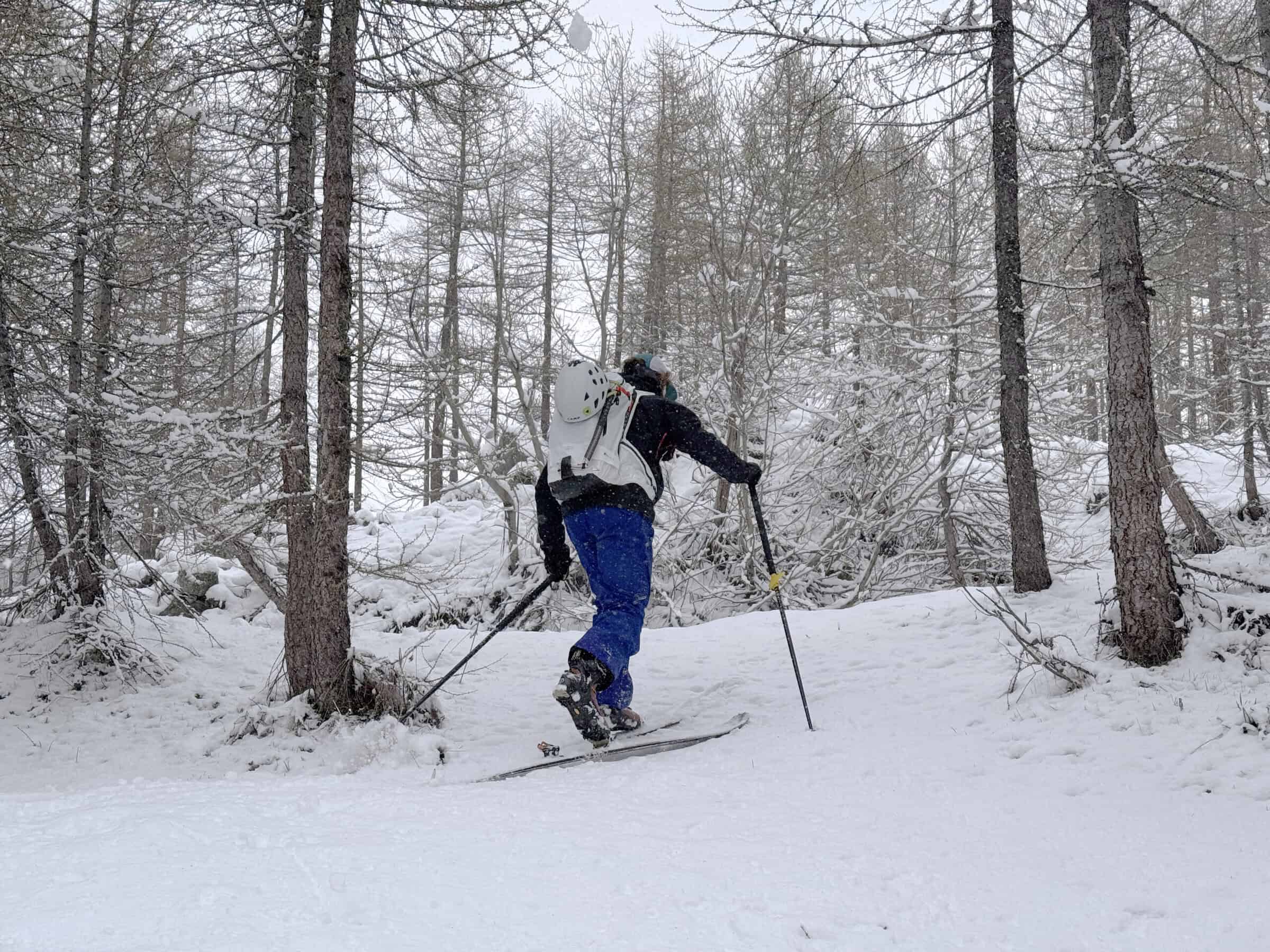 Tester in salita con gli scarponi SCARPA F1-RS e zaino airbag ARVA nel bosco innevato di Cervinia durante la sessione test Outdoortest.it inverno 26/27