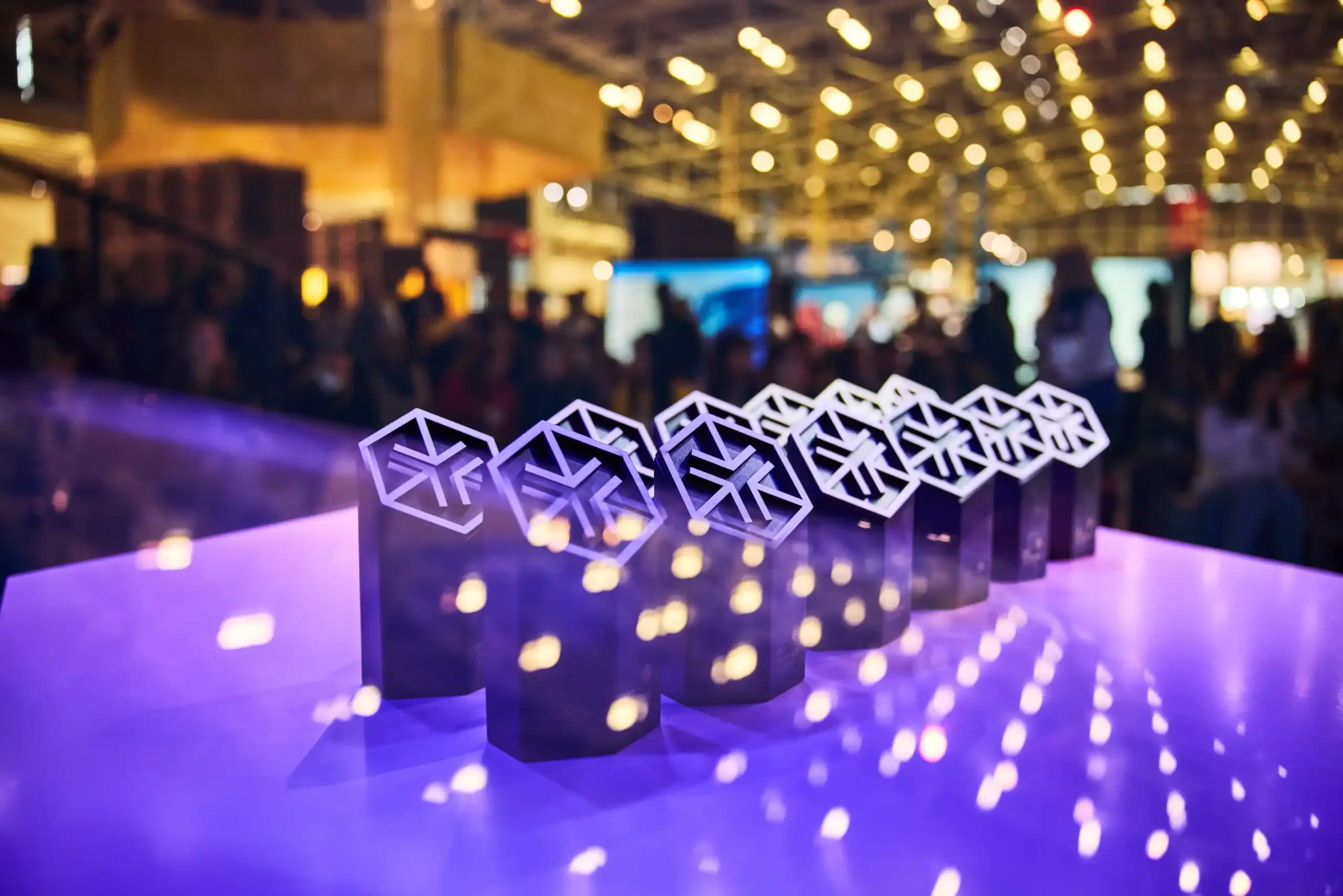 Trofei degli ISPO Excellence Awards 2026 illuminati di viola sul palco della cerimonia di premiazione ad Amsterdam