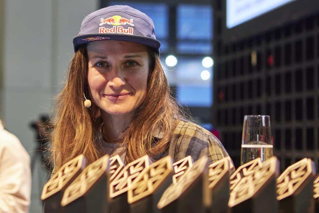 Ospite con cappellino Red Bull sorridente davanti ai trofei degli ISPO Excellence Awards 2026 durante la cerimonia di premiazione ad Amsterdam