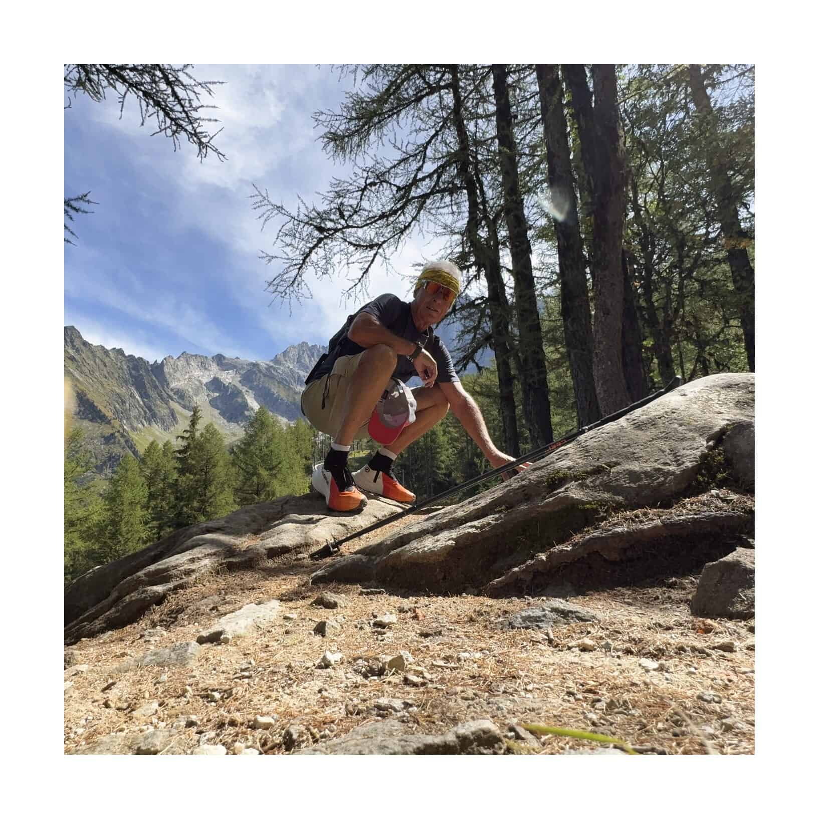 Il tester Outdoortest accovacciato su una roccia con le SCARPA Alien Ultra ai piedi