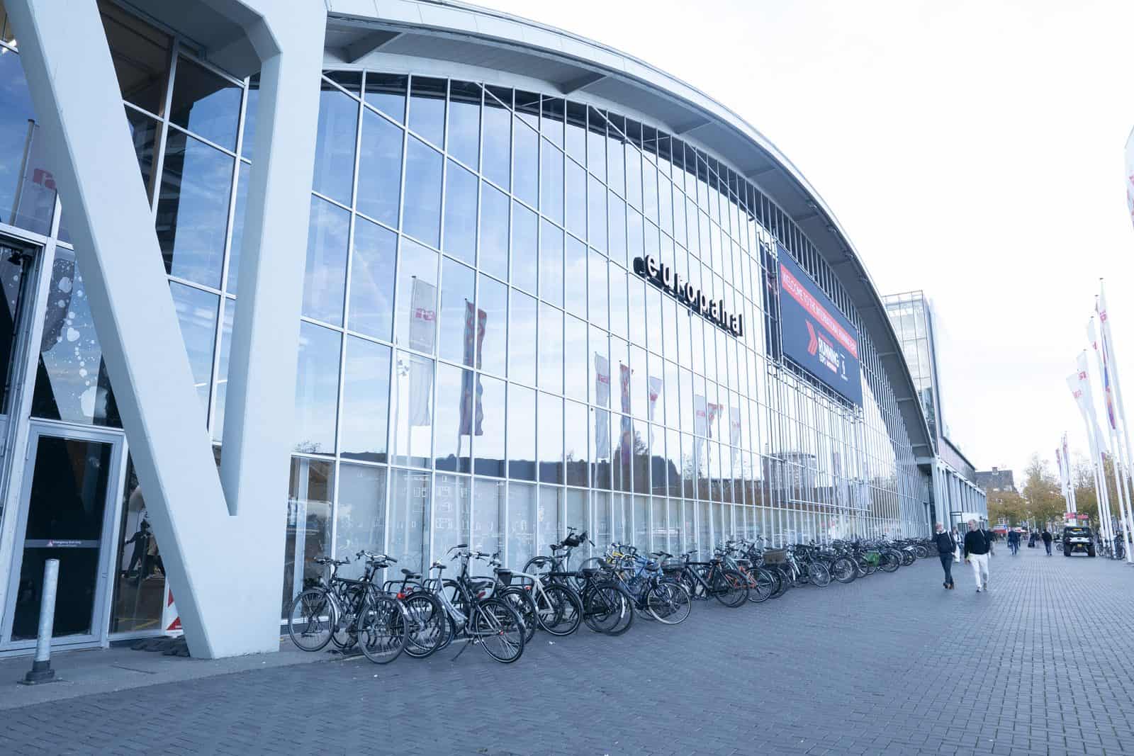 ISPO Amsterdam 2026: biciclette parcheggiate davanti alla facciata vetrata dell'Europahal del RAI